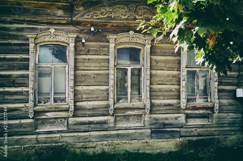 Old russian traditional wooden house facade with carved windows photo