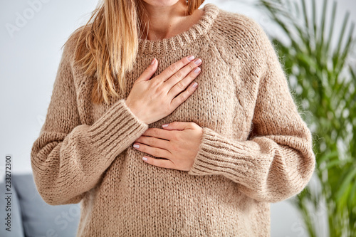 Canvas Print Young woman with heart problem holding chest.