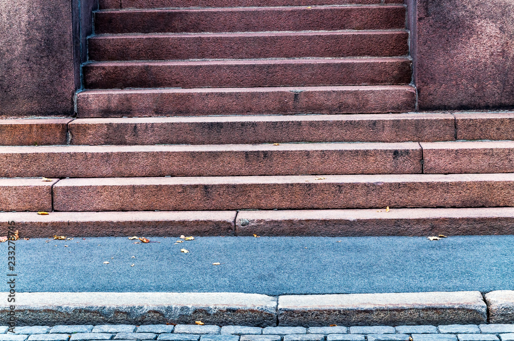 Detail of urban building entrance with aged and weathered stone stair facing the street and sidewalk in the city - Old architectural facade with steps in geometric shape and lines