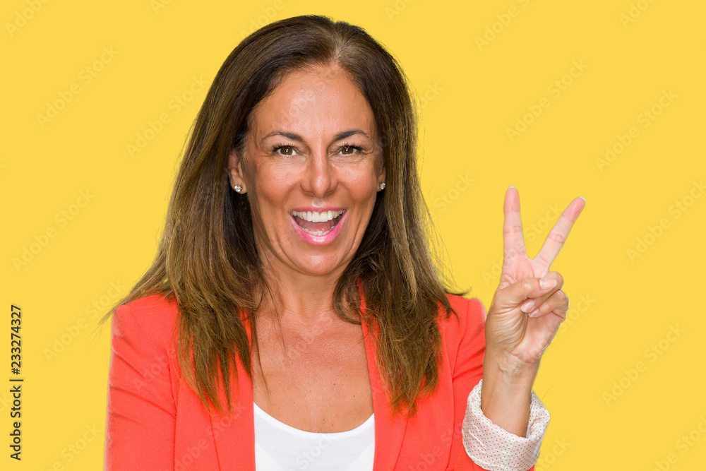 Beautiful middle age business adult woman over isolated background smiling with happy face winking at the camera doing victory sign. Number two. Beautiful middle age business adult woman over isolated background smiling with happy face winking at the camera doing victory sign. Number two.