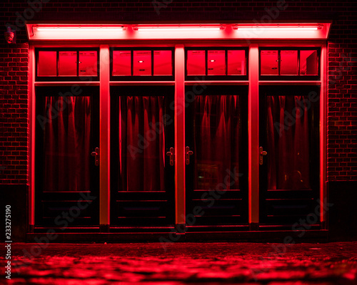 Obraz na płótnie Red Light District in Amsterdam. Red boxes with curtains and wet Cobbles on the street w salonie