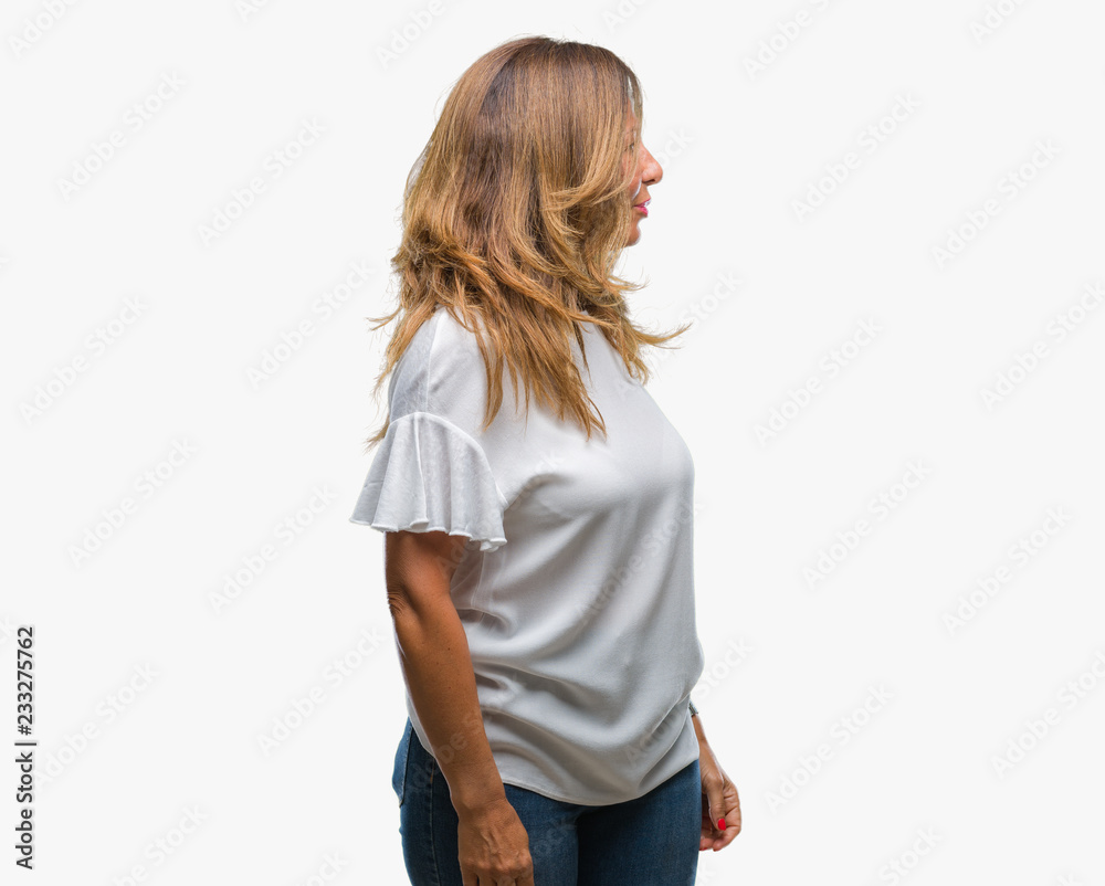 Middle age senior hispanic woman over isolated background looking to side, relax profile pose with natural face with confident smile.