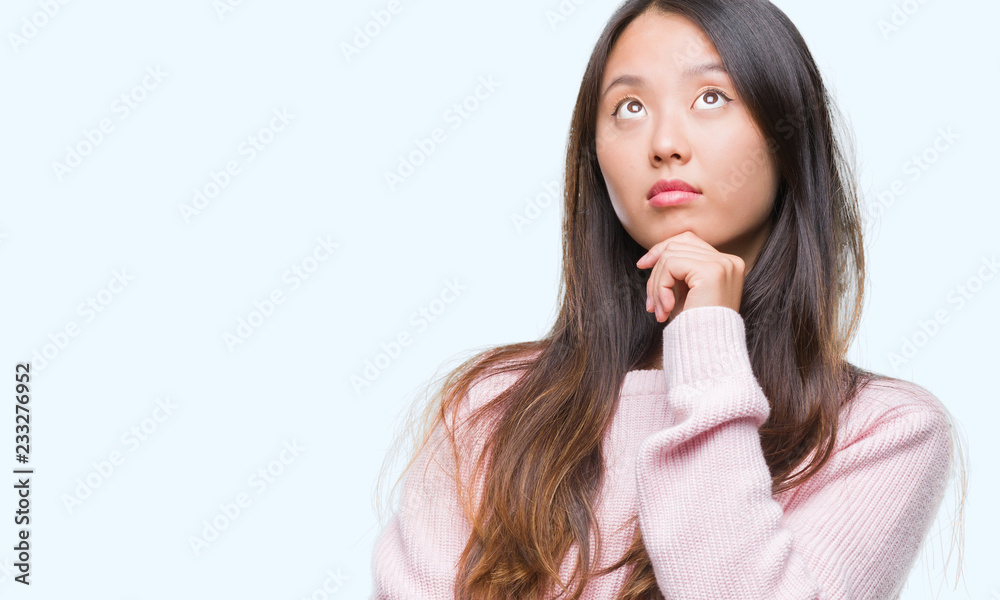 Young asian woman over isolated background with hand on chin thinking about question, pensive expression. Smiling with thoughtful face. Doubt concept. Young asian woman over isolated background with hand on chin thinking about question, pensive expression. Smiling with thoughtful face. Doubt concept.