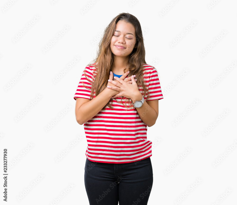 Young beautiful brunette woman wearing stripes t-shirt over isolated background smiling with hands on chest with closed eyes and grateful gesture on face. Health concept. Young beautiful brunette woman wearing stripes t-shirt over isolated background smiling with hands on chest with closed eyes and grateful gesture on face. Health concept.