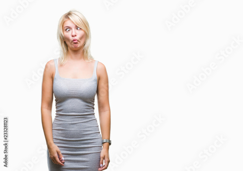Young beautiful blonde woman over isolated background making fish face with lips, crazy and comical gesture. Funny expression. © Krakenimages.com