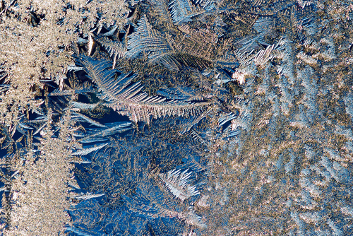 Frosted window. Ice patterns on glass surface.