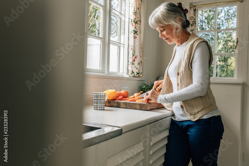 Senior woman working in kitchen at home