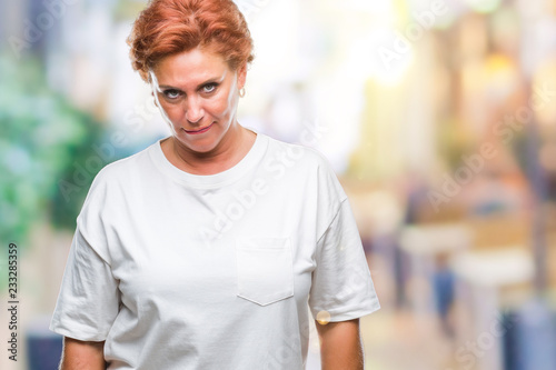 Atrractive senior caucasian redhead woman over isolated background skeptic and nervous, frowning upset because of problem. Negative person.