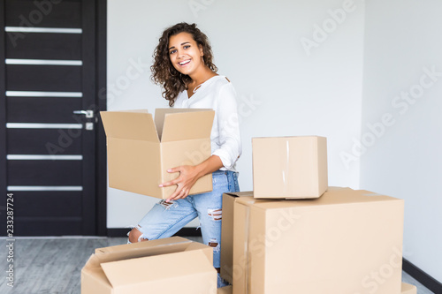 Happy smiling mixed race woman carrying carton boxes moving to new apartment © F8  \ Suport Ukraine