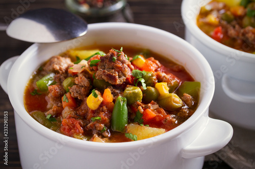 Delicious hamburger soup with vegetables: peas, corn, carrots, potatoes, tomatoes and green beans (can be cooked with frozen vegetables). horizontal
