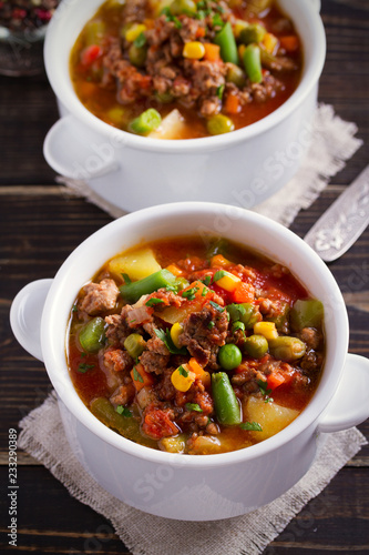 Delicious hamburger soup with vegetables: peas, corn, carrots, potatoes, tomatoes and green beans (can be cooked with frozen vegetables). vertical