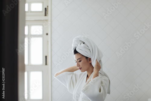 Portrait of beautiful Thai woman wearing a bathrobe and a towel on her head.