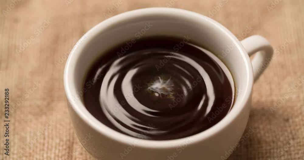 Milk droplet falling and splashing into Cup with black coffee Close up Macro shot Slow Motion video Milk droplet falling and splashing into Cup with black coffee Close up Macro shot Slow Motion video