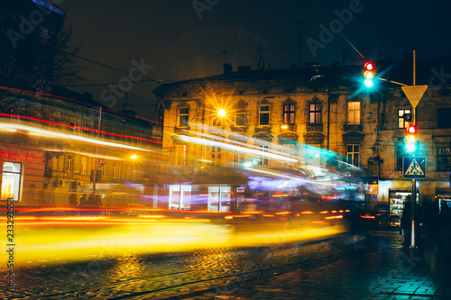 Lviv night car trails on the vintage building background, ukraine