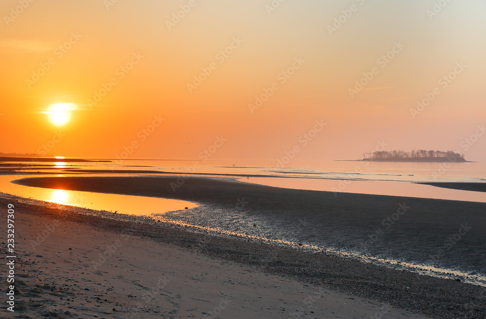 Overview of beautiful Silver Sands Beach at sunrise at low tide at