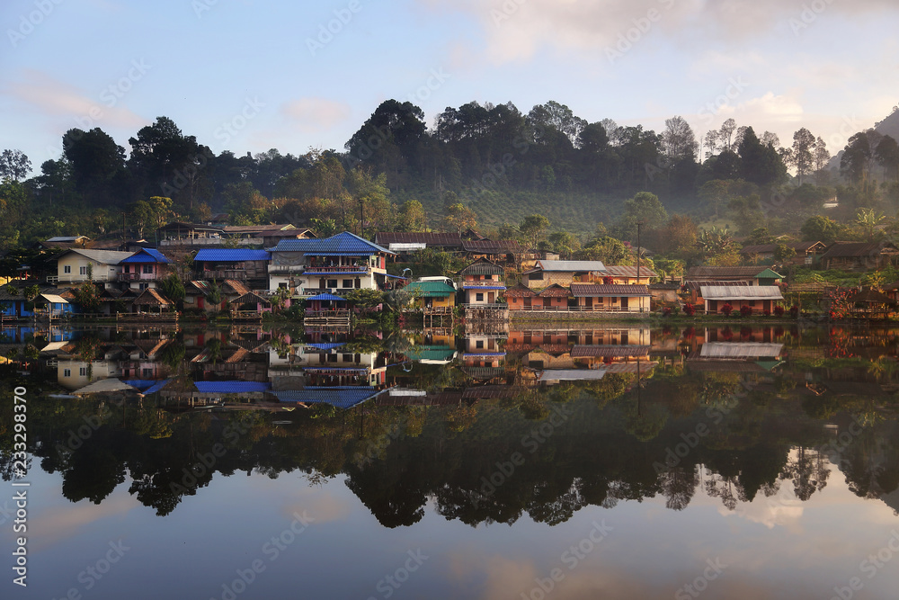 Beautiful scenery during sunrise with the mist and water reflection of the Chinese village at the Lee wine ruk thai lake, Mae Hong Son in Thailand is a very popular for photographers and tourists