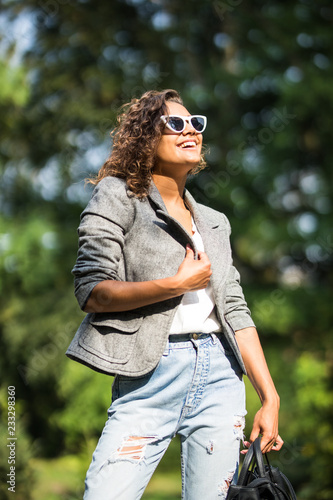 Young beautiful woman in suit and sunglasses at sunny day