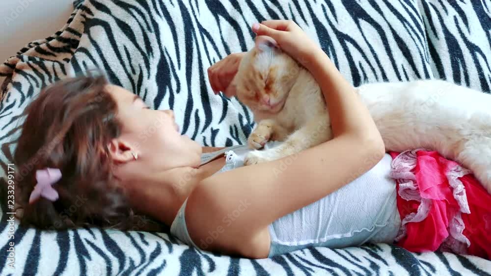 little girl hugging a cat lying on the bed. girl and pet white cat friendship care love. girl and cat concept lifestyle little girl hugging a cat lying on the bed. girl and pet white cat friendship care love. girl and cat concept lifestyle