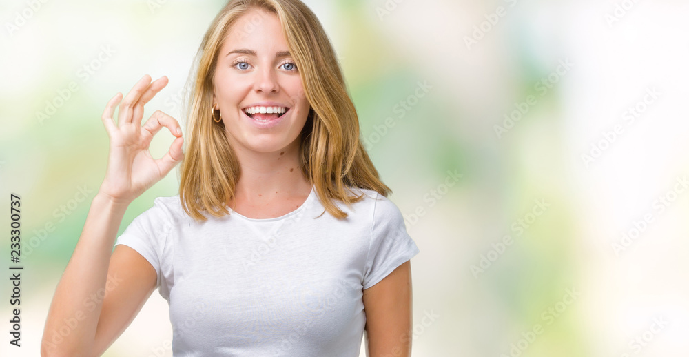 Beautiful young woman wearing casual white t-shirt over isolated background smiling positive doing ok sign with hand and fingers. Successful expression.