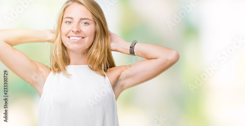 Beautiful young elegant woman over isolated background Relaxing and stretching with arms and hands behind head and neck, smiling happy