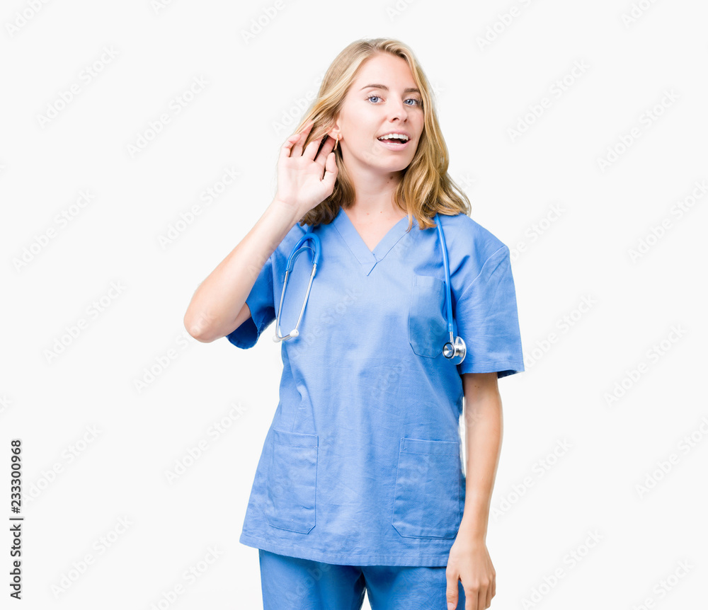 Beautiful young doctor woman wearing medical uniform over isolated background smiling with hand over ear listening an hearing to rumor or gossip. Deafness concept. Beautiful young doctor woman wearing medical uniform over isolated background smiling with hand over ear listening an hearing to rumor or gossip. Deafness concept.
