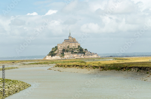 Panoramic view of famous Le Mont Saint-Michel tidal island on a sunny day with blue sky and clouds, Normandy, northern France photo