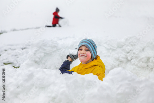 boy playing in a snow fort. snowball game. The concept of winter fun
