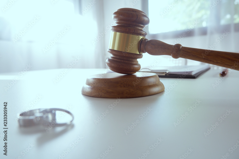 wedding rings and Judge gavel hammer on Lawyer desk. wedding rings and Judge gavel hammer on Lawyer desk.