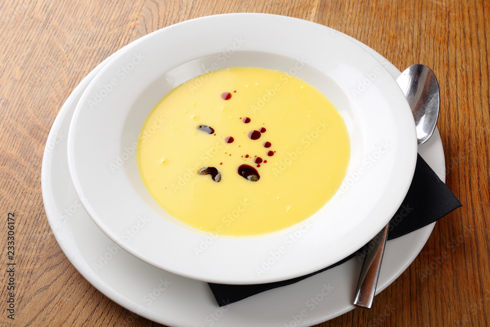 Bright yellow beautiful soup in a white plate Bright yellow beautiful soup in a white plate