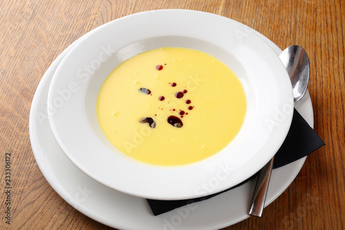 Bright yellow beautiful soup in a white plate