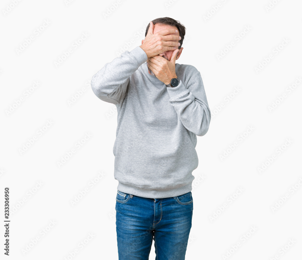 Fototapeta premium Handsome middle age senior man wearing a sweatshirt over isolated background Covering eyes and mouth with hands, surprised and shocked. Hiding emotion
