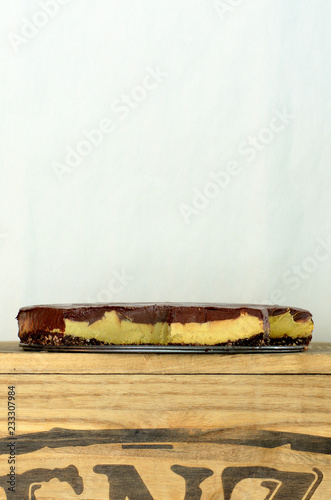 A slice of vegan cheesecake covered in chocolate