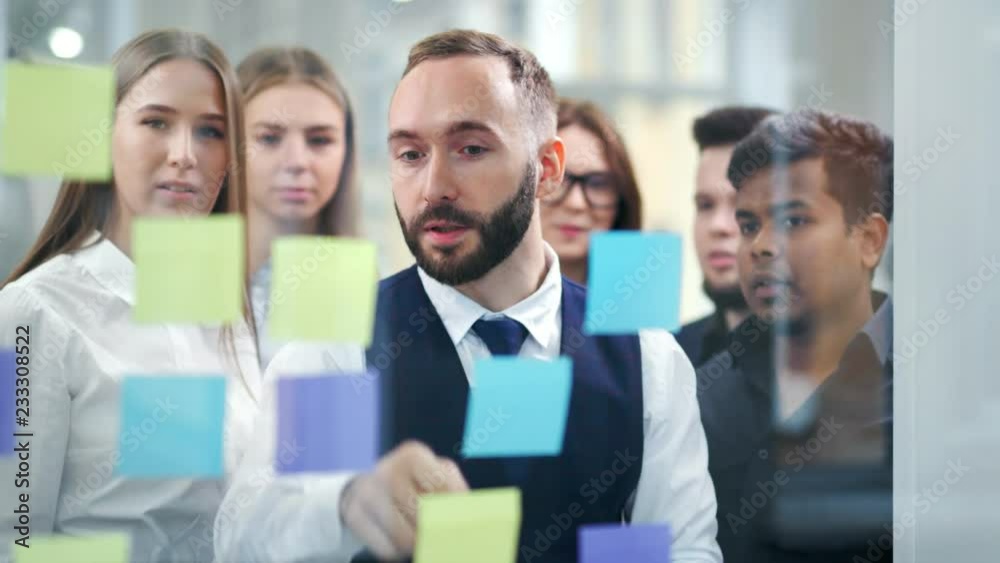Multiethnic business people team meeting and brainstorming working with multi colored stickers notes