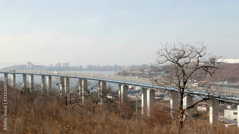 The bridge from Cape Churkin to Russky Island through the Bosphorus East in the Far Eastern city of Vladivostok. The movement of cars on the mainland of the Russian or Russky Bridge. The bridge from Cape Churkin to Russky Island through the Bosphorus East in the Far Eastern city of Vladivostok. The movement of cars on the mainland of the Russian or Russky Bridge.