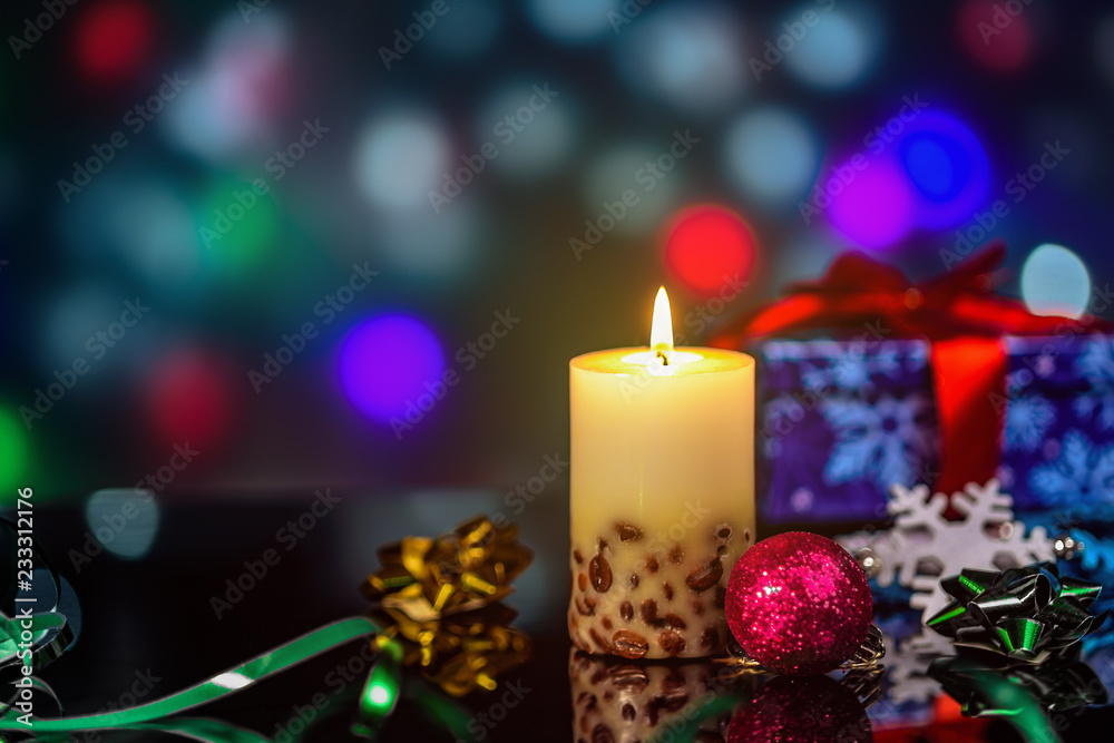 burning candles and Christmas decorations on table with reflection on bokeh background with blurred background