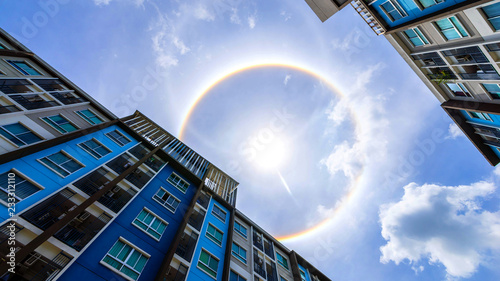building and sun corona rainbow clouds and blue sky background , Circumscribed halo