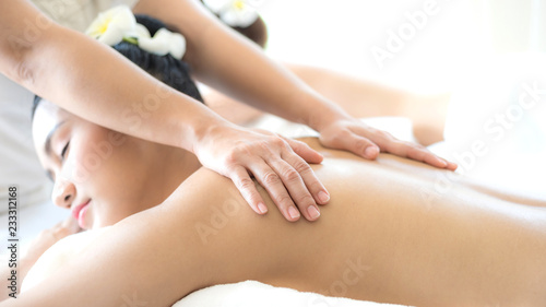 beautiful and healthy young woman relaxing with back massage in spa salon
