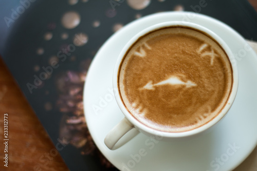 Closeup of A cup of Latte Art hot coffee over wooden table top background in coffee's shop