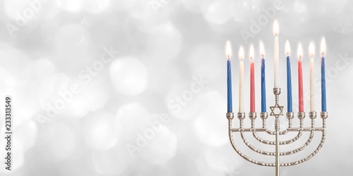Hanukkah Chanukah Jewish holiday background with menorah (Judaism candelabra) for Festival of Lights and Feast of Dedication with burning candles and traditional on white silver winter snow bokeh