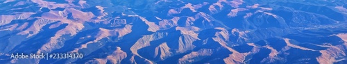 Aerial view of topographical Rocky Mountain landscapes on flight over Colorado and Utah during autumn. Grand sweeping views of rivers, mountain and landscape patterns. Top view, Rockies and Wasatch