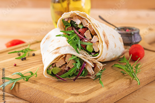 Tortillas wraps with chicken and vegetables on  wooden background. Chicken burrito. Healthy food.
