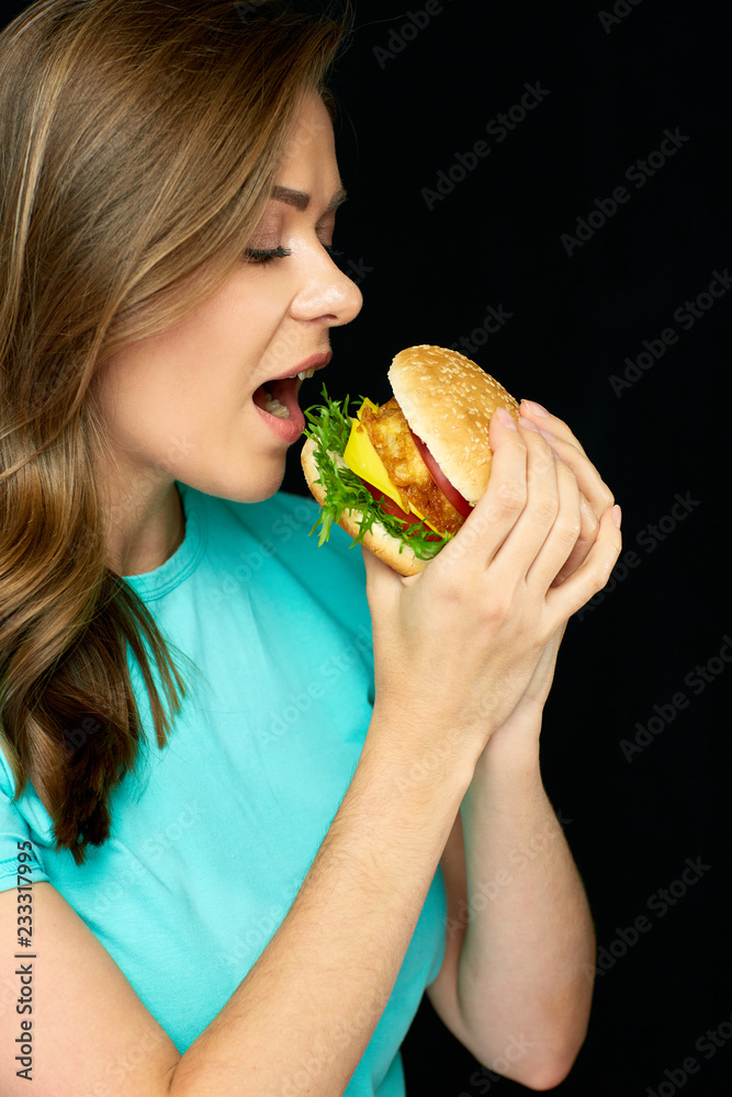 Woman eating cheeseburger, isolated portrait Woman eating cheeseburger, isolated portrait