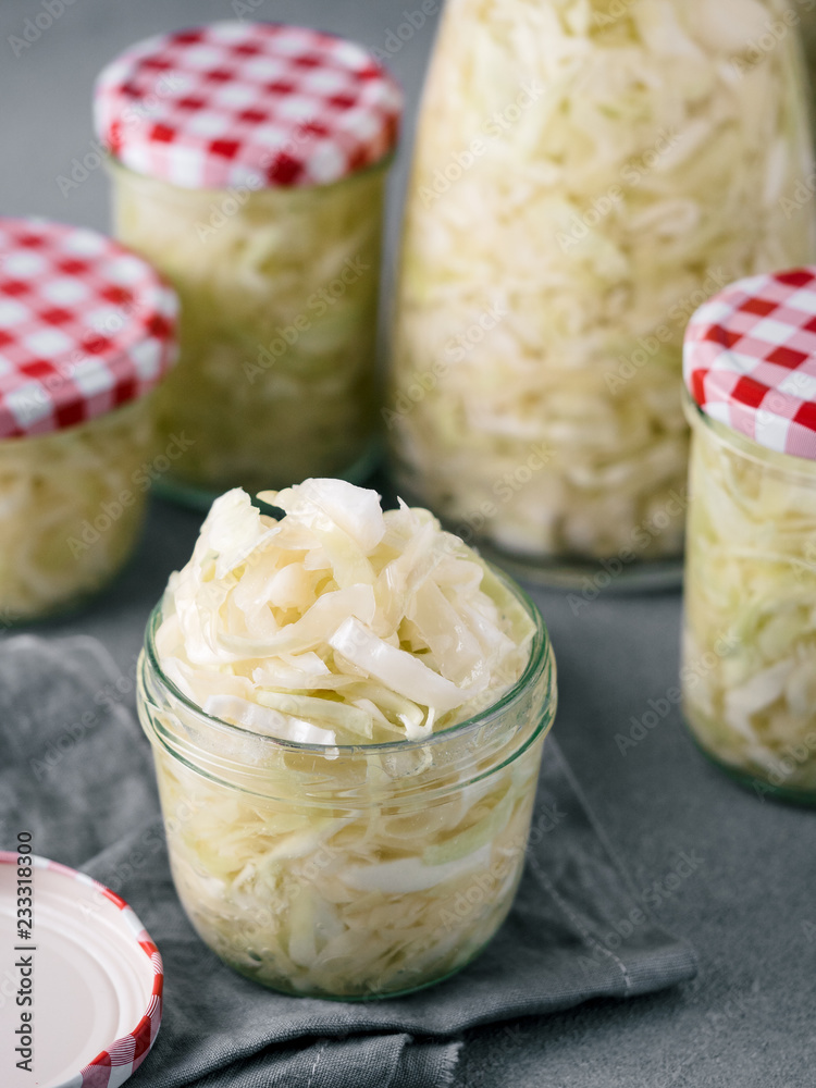 Sauerkraut in open glass mason jar. Pickling cabbage at home on table. The best natural probiotic. Homemade kraut., copy space for text. Vertical. Sauerkraut in open glass mason jar. Pickling cabbage at home on table. The best natural probiotic. Homemade kraut., copy space for text. Vertical.