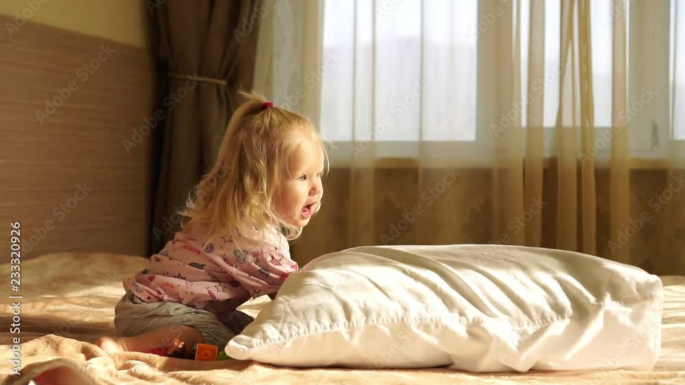 Little baby girl on the bed playing with toys, slow motion. Little baby girl on the bed playing with toys, slow motion.