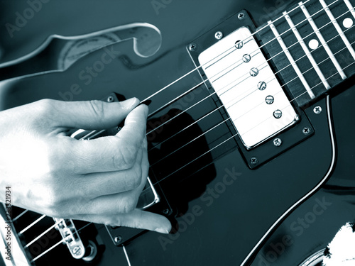 Canvas Print close up of hand playing black vintage electric jazz guitar hollow body