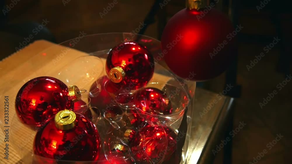 Girls hand taking red shiny bulb out of the box when decorating christmas tree. Family time filmed in slow motion hd. Girls hand taking red shiny bulb out of the box when decorating christmas tree. Family time filmed in slow motion hd.