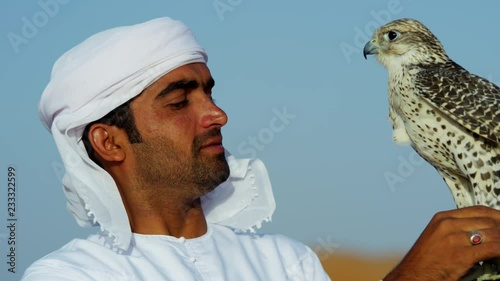 Proud Arab wearing dishdasha with his trained falcon photo