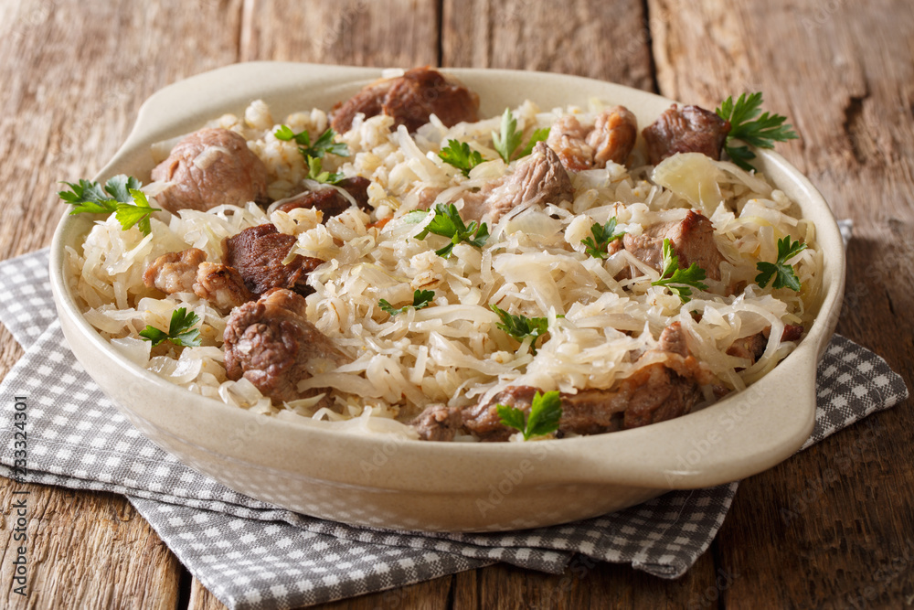 Estonian main course Mulgikapsas cooked pork with sauerkraut, onions and barley closeup in a dish. horizontal Estonian main course Mulgikapsas cooked pork with sauerkraut, onions and barley closeup in a dish. horizontal