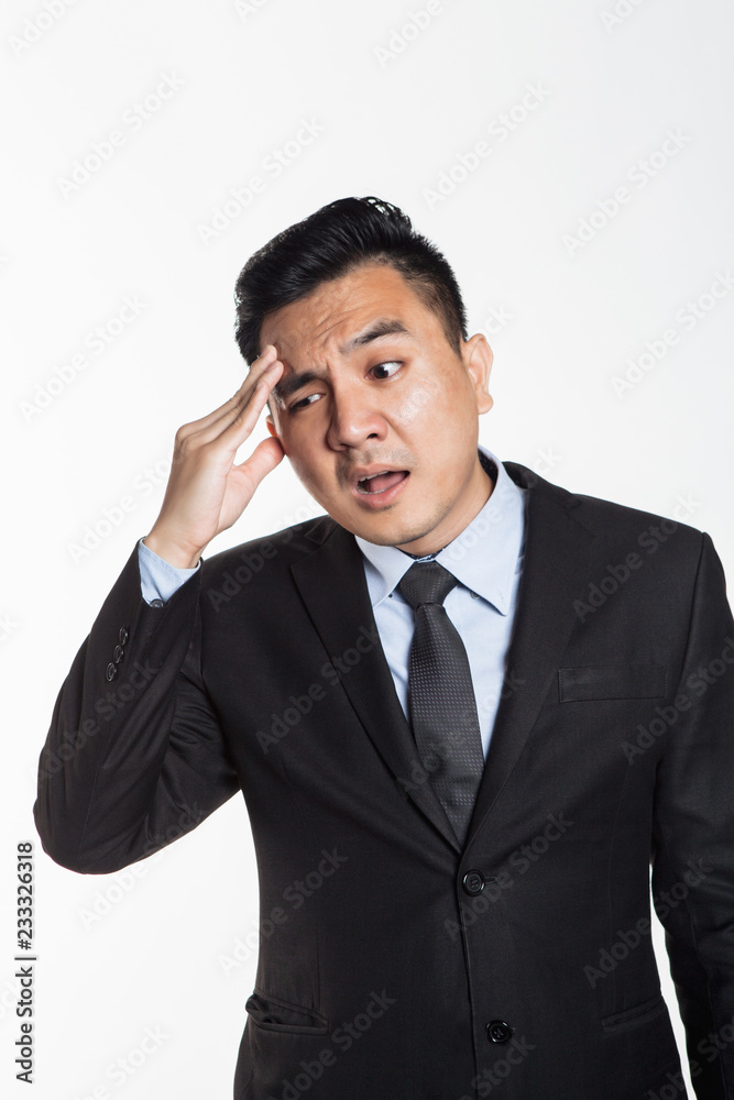 Asian man in business suit having headache Asian man in business suit having headache