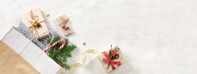 Christmas banner. Winter Holidays sale background. Shopping bag, presents with candy cane, fir branch and golden ribbon. Top view, copy space
